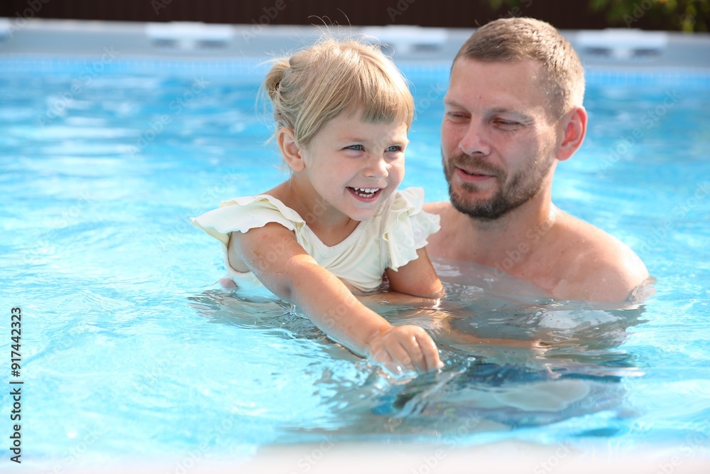 Happy father having fun with his daughter in swimming pool Happy father having fun with his daughter in swimming pool
