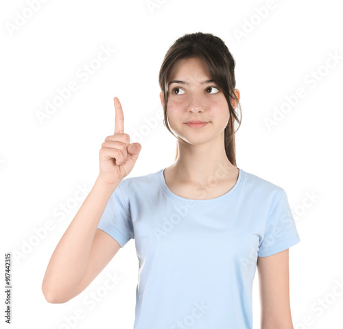 Portrait of cute teenage girl pointing at something on white background