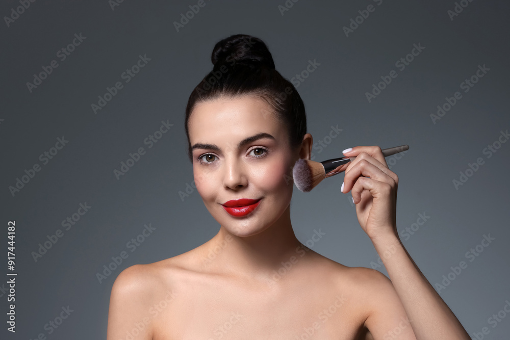 Beautiful makeup. Attractive woman with brush on grey background Beautiful makeup. Attractive woman with brush on grey background