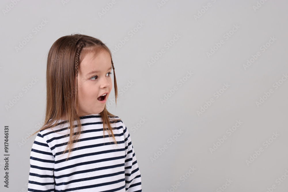 Portrait of emotional little girl on grey background, space for text Portrait of emotional little girl on grey background, space for text