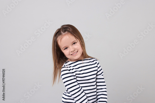 Portrait of happy little girl on grey background