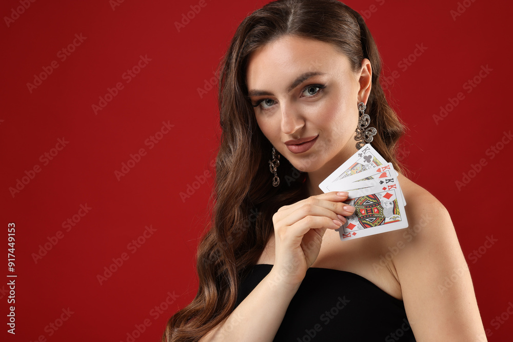 Poker game. Charming woman with playing cards on red background. Space for text Poker game. Charming woman with playing cards on red background. Space for text