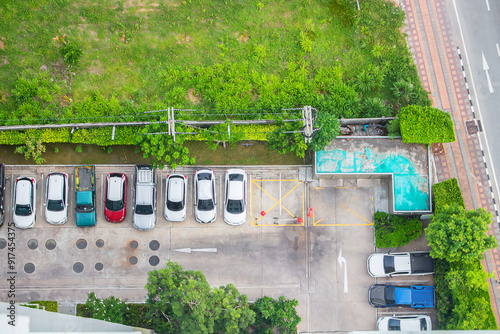 Top view of parking area with small garden in modern building.