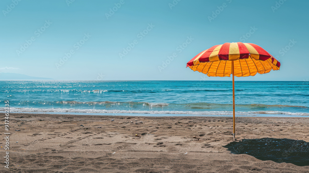 A photographic style of a yellow and red striped beach umbrella, open and providing shade on a sunny beach, blue ocean waves in the background A photographic style of a yellow and red striped beach umbrella, open and providing shade on a sunny beach, blue ocean waves in the background