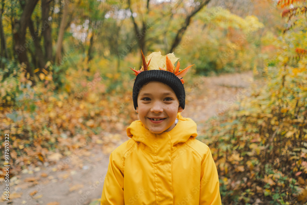 A joyful child dressed in a bright yellow raincoat walks along a serene forest path covered with vibrant autumn leaves. Autumn mood. Beautiful autumn A joyful child dressed in a bright yellow raincoat walks along a serene forest path covered with vibrant autumn leaves. Autumn mood. Beautiful autumn