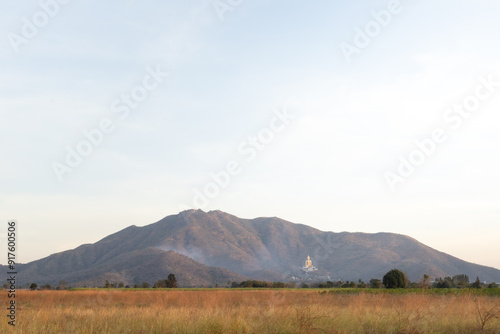 Summer scenery with beautiful fields and mountains, Landmark big Buddha statue on the mountain, Khao Wong Phrachan Temple, Lopburi, Thailand photo