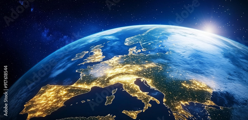 The view captures Europe sparkling at night from space, with the sun rising on the horizon, highlighting the continent's cities.
