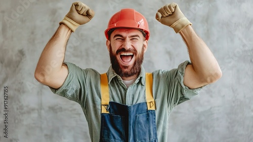 Construction Worker's Triumph: A jubilant construction worker, clad in overalls and a hard hat, throws his fists in the air, radiating pure joy and accomplishment.  photo