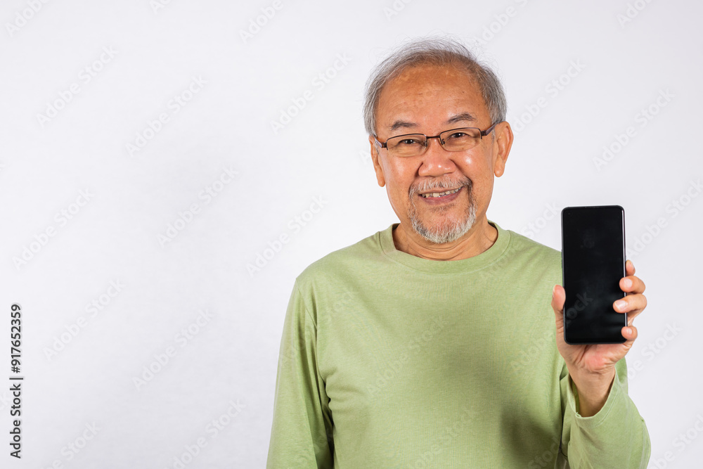 Portrait Asian smiling old man holding a cell phone blank screen studio shot isolated on white background, happy senior man showing mobile phone display mockup, App advertisement Portrait Asian smiling old man holding a cell phone blank screen studio shot isolated on white background, happy senior man showing mobile phone display mockup, App advertisement
