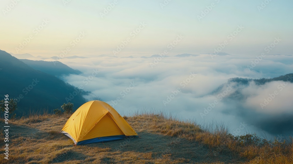 yellow tent on the top of the mountain with the sunrise and fog and mountains yellow tent on the top of the mountain with the sunrise and fog and mountains