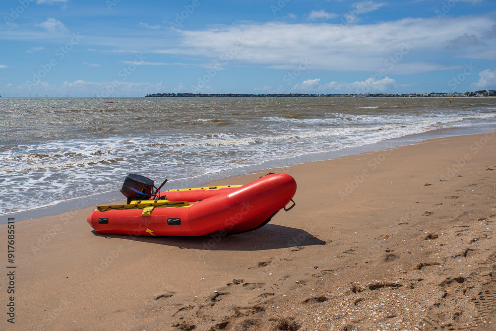 Red inflatable boat on a beach in Brittany in summer in France Red inflatable boat on a beach in Brittany in summer in France