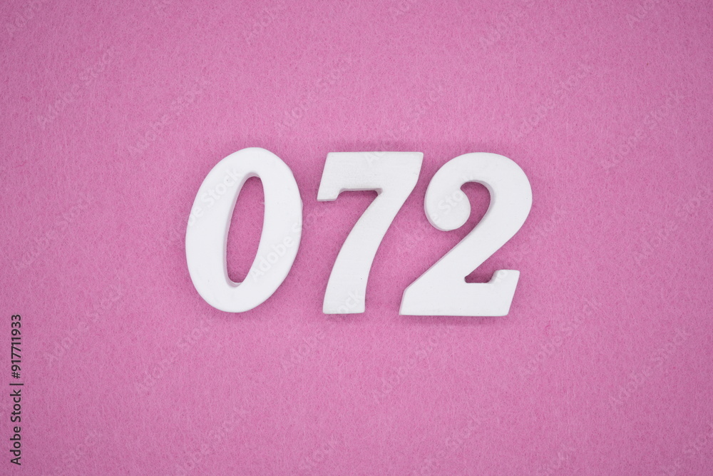 The numbers are made of white painted wood. Laying on the floor was pink paper. The numbers are made of white painted wood. Laying on the floor was pink paper.