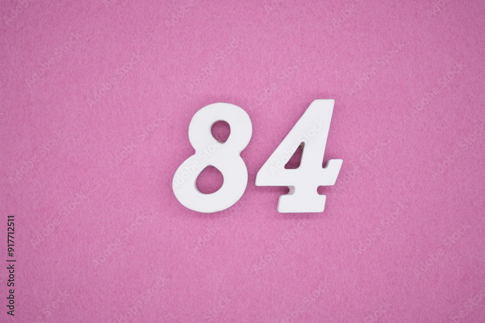 The numbers are made of white painted wood. Laying on the floor was pink paper. The numbers are made of white painted wood. Laying on the floor was pink paper.