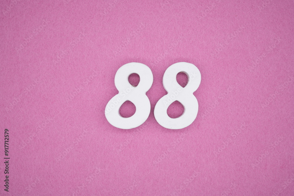The numbers are made of white painted wood. Laying on the floor was pink paper. The numbers are made of white painted wood. Laying on the floor was pink paper.