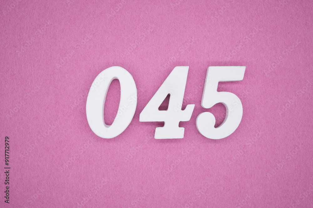 The numbers are made of white painted wood. Laying on the floor was pink paper. The numbers are made of white painted wood. Laying on the floor was pink paper.