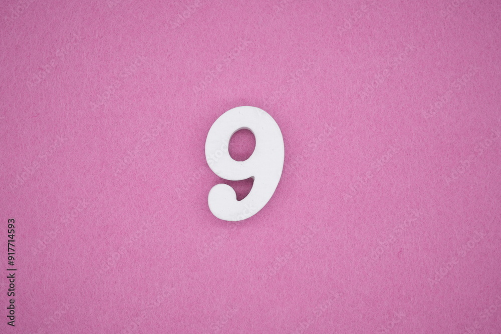 The numbers are made of white painted wood. Laying on the floor was pink paper. The numbers are made of white painted wood. Laying on the floor was pink paper.