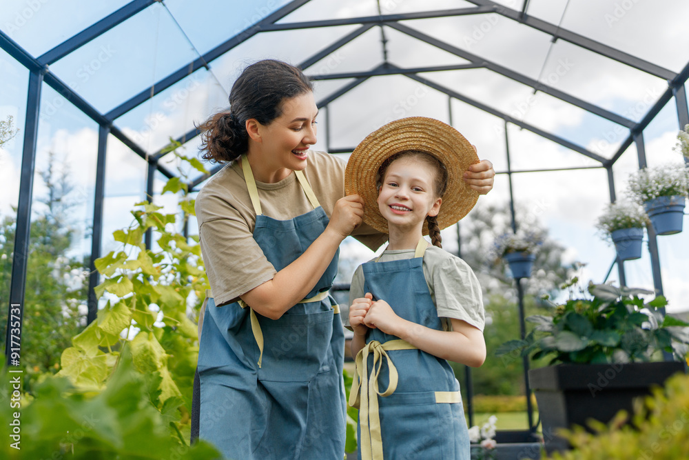 mother and daughter are gardening in the greenhouse mother and daughter are gardening in the greenhouse