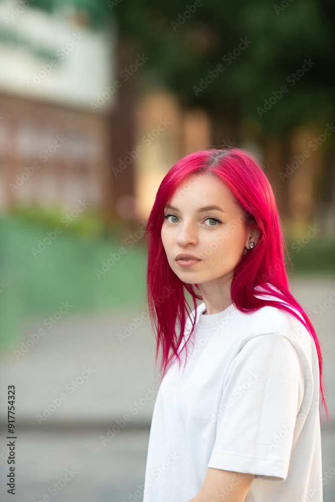 Portrait of a young red-haired girl in the park.