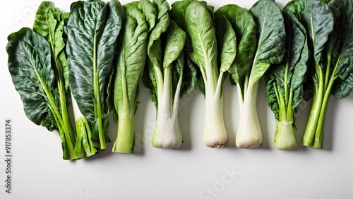 Organic greens including Swiss chard collard greens and bok choy on white background with ample copy space Leafy vegetable concept photo