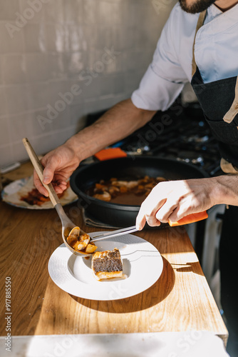 Private chef serving fish dish in a modern kitchen photo