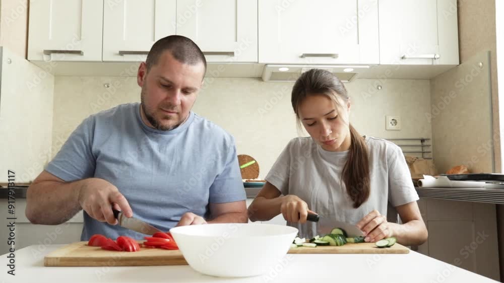 Teenage girl and father cooking salad at the kitchen, girl and father peeling and cutting vegetables, parent and child enjoying breakfast. Teenage girl and father cooking salad at the kitchen, girl and father peeling and cutting vegetables, parent and child enjoying breakfast.