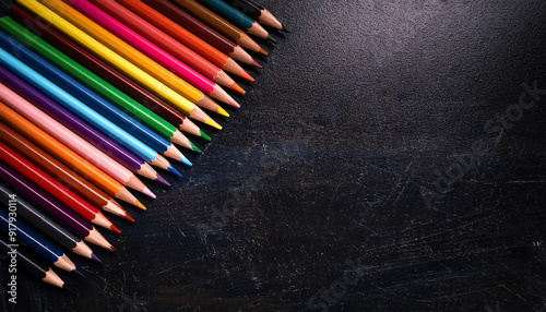 Flatlay. Copy space. A set of colorful pencils against a dark chalkboard photo