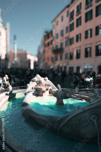 Elegant stone fountain with turquoise water in a bustling city square, surrounded by historic buildings and lively crowds under a clear sky