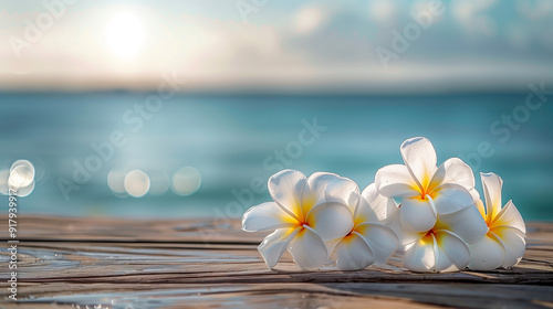 White flowers on a wooden dock with ocean background.