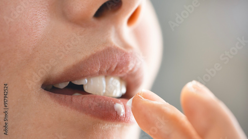 Young woman applying lip balm photo