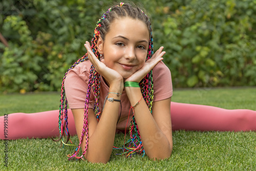 Flexible young girl does the spits and rests her head in her hands. Horizontally. 