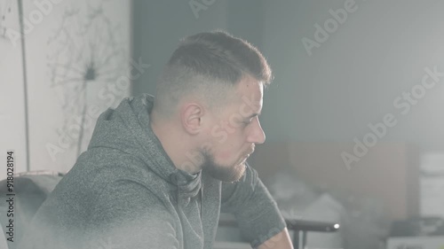 Man deep in thought with soft lighting in a modern room, A man is captured deep in thought, with a soft, diffused light filling the modern room. photo