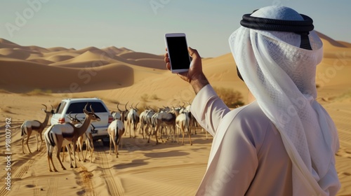 Saudi Arabia man on jeep points his smartphone on herd of gazelles and gets tick mark photo