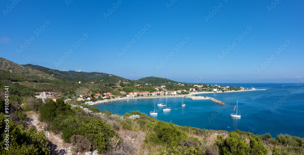Amazing view down to the sea and the harbor village from the mountain in Othonoi island, Greece Amazing view down to the sea and the harbor village from the mountain in Othonoi island, Greece