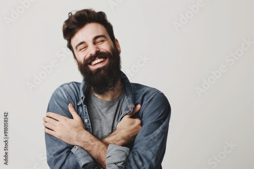 Attractive man with a beard hugs himself, this symbolizes self care 