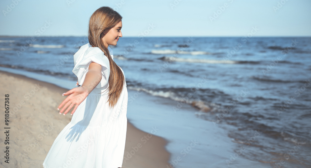 Happy, beautiful woman on the ocean beach standing in a white summer dress, open arms Happy, beautiful woman on the ocean beach standing in a white summer dress, open arms