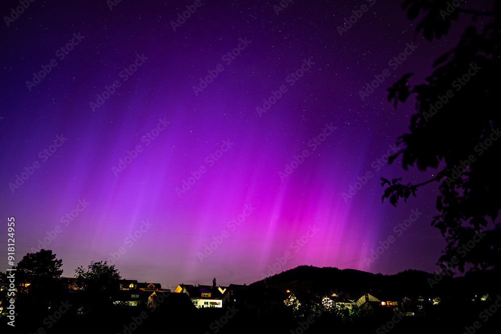 The Northern Lights shimmer gracefully in the summer sky, casting a vibrant display of green and purple hues across the tranquil landscape. The Northern Lights shimmer gracefully in the summer sky, casting a vibrant display of green and purple hues across the tranquil landscape.