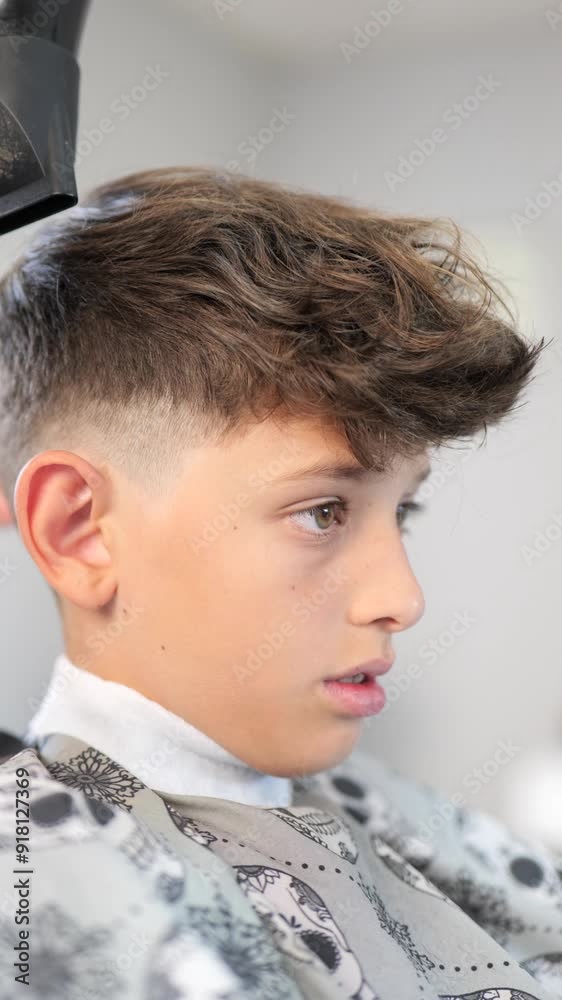Vertical video of a young boy at the hairdresser having a haircut Vertical video of a young boy at the hairdresser having a haircut