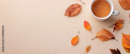 Warm Tea Surrounded By Autumn Leaves on a Beige Surface
