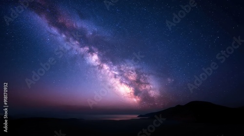 A stunning night sky filled with stars, featuring the Milky Way galaxy prominently. The dark, clear night with silhouettes of distant hills evokes a sense of awe and infinity.