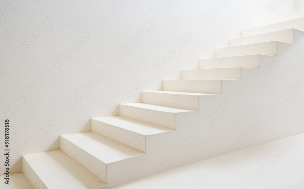 White stairs on white plastered wall. Background. White steps in stilish interior White stairs on white plastered wall. Background. White steps in stilish interior