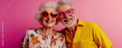 Crazy smiling senior couple, isolated pink color background, image with space for text