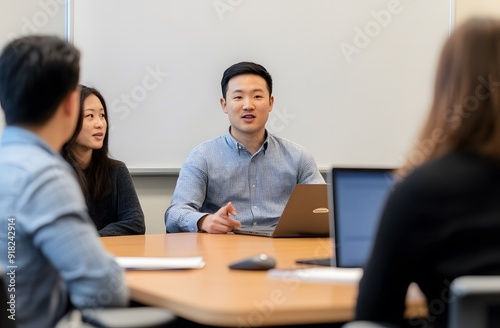 Asian businessman presenting to his team in the board room