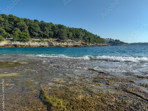 Fototapeta Naklejka Na Ścianę i Meble -  Sunset at a beautiful Gortan bay in Adriatic sea in Pula Croatia. Blue sea and sky, sand beach and rocks