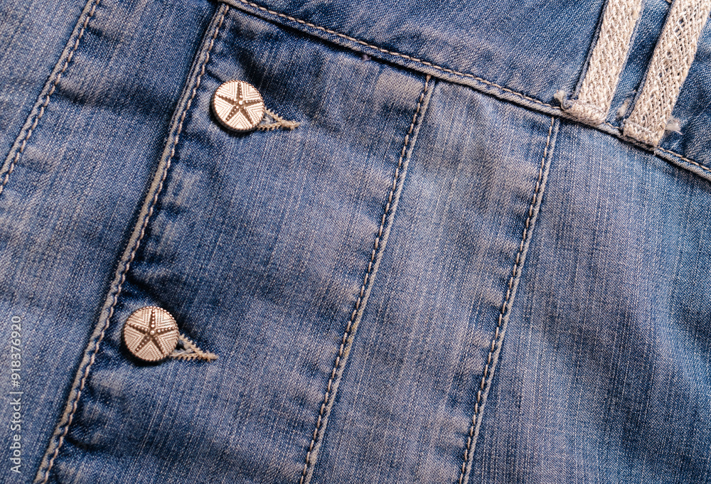 Detailed shot of a blue denim jacket with metal buttons Detailed shot of a blue denim jacket with metal buttons