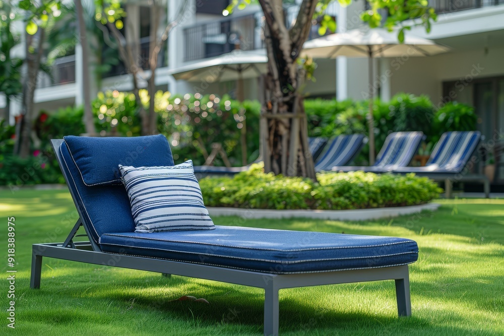 Blue and white outdoor sunbed with a striped pillow on the lawn of an apartment complex in Thailand, captured in professional photography style. Blue and white outdoor sunbed with a striped pillow on the lawn of an apartment complex in Thailand, captured in professional photography style.