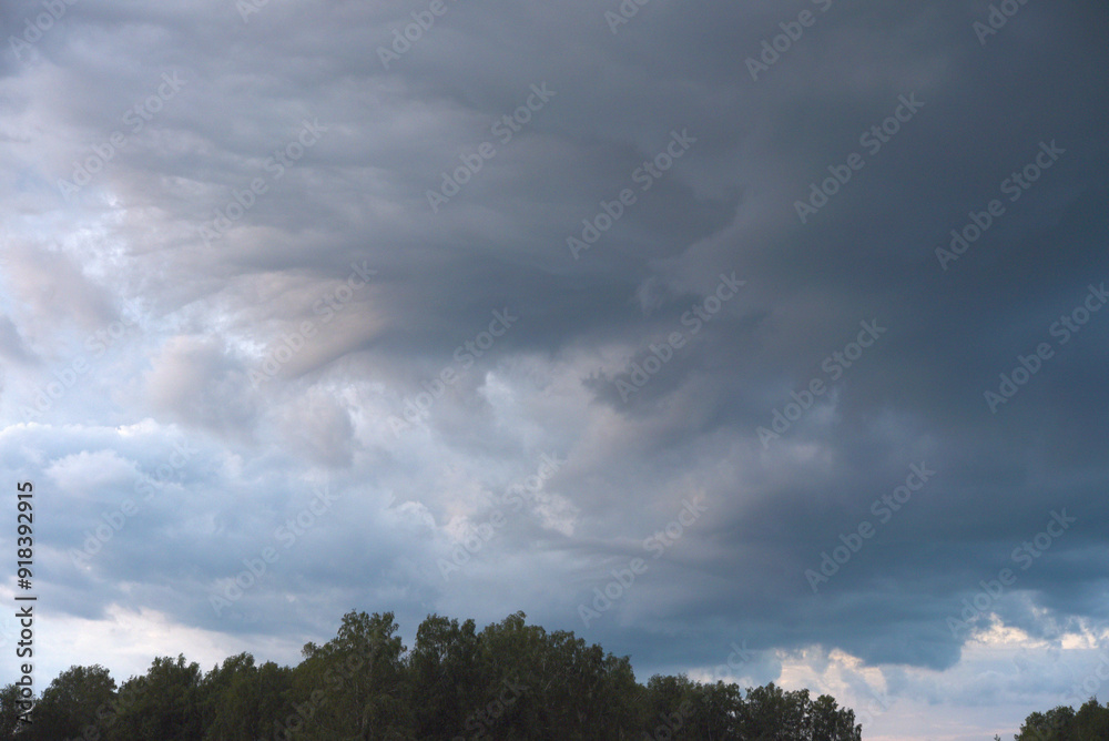 Cumulus rain clouds in the evening sky. Thunderclouds over the forest. Cumulus rain clouds in the evening sky. Thunderclouds over the forest.