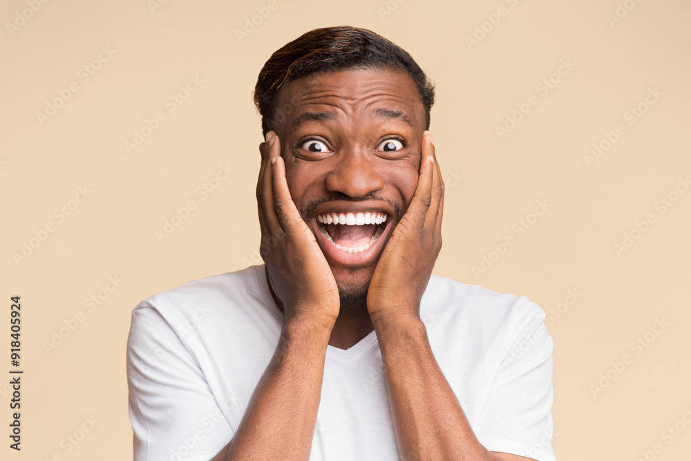Omg. Excited African American Guy Looking At Camera With Open Mouth Touching Face Over Yellow Studio Background. Omg. Excited African American Guy Looking At Camera With Open Mouth Touching Face Over Yellow Studio Background.