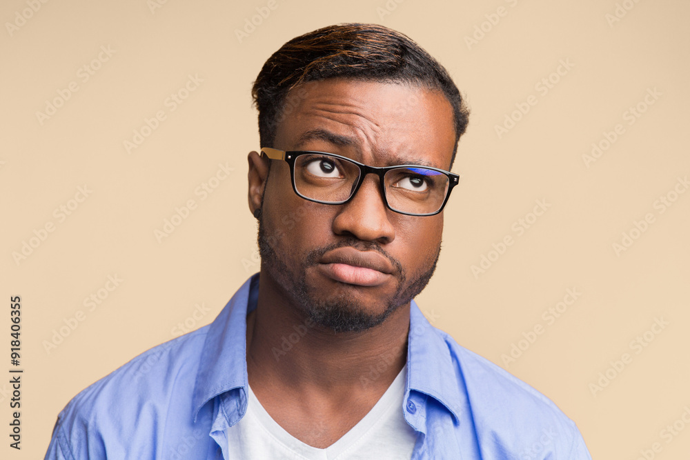 Puzzled African American Man Thinking About Something Standing Over Orange Studio Background. Puzzled African American Man Thinking About Something Standing Over Orange Studio Background.