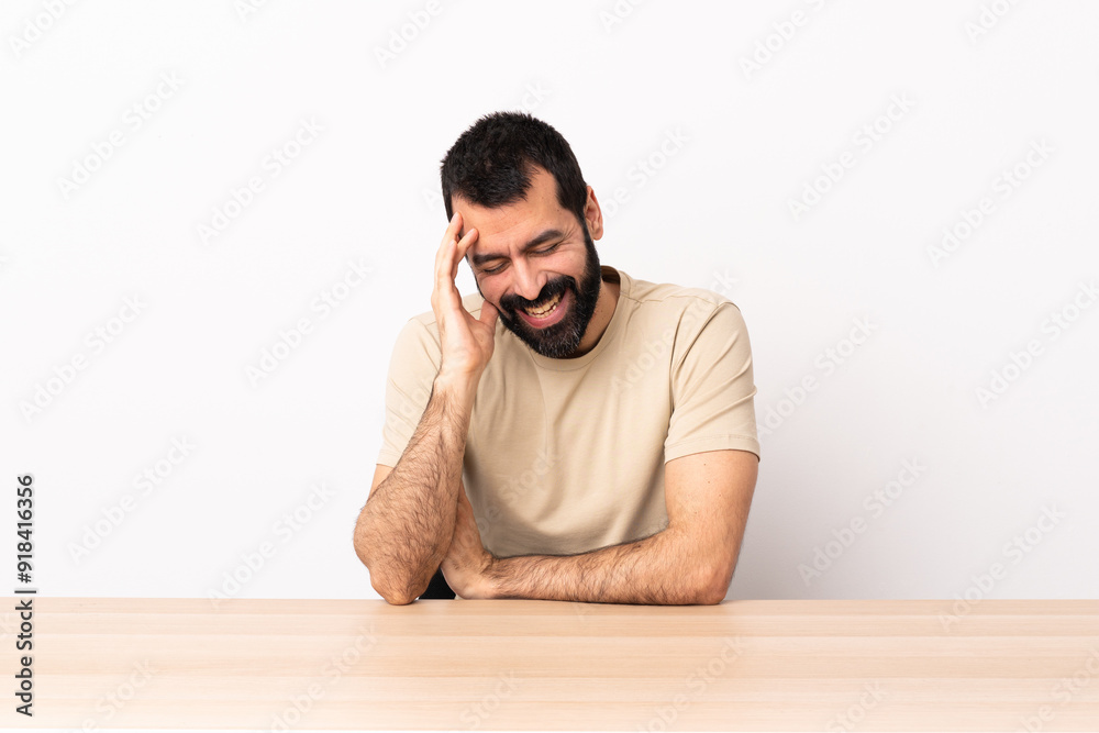 Caucasian man with beard in a table laughing. Caucasian man with beard in a table laughing.