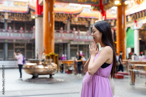Asian pregnant woman pray at chinese temple